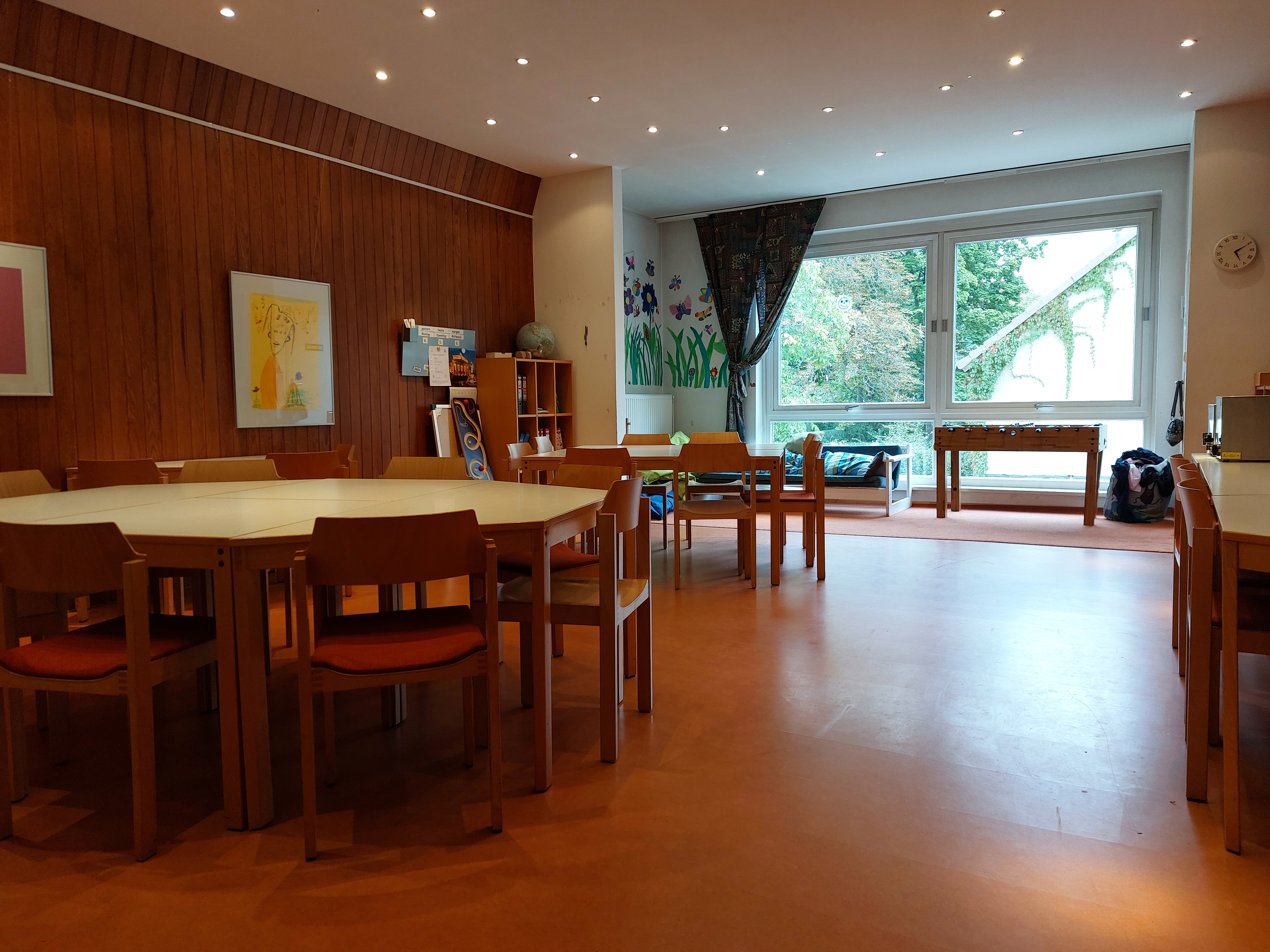 Blick in den Clubraum mit Tisch, Fenster und Kicker